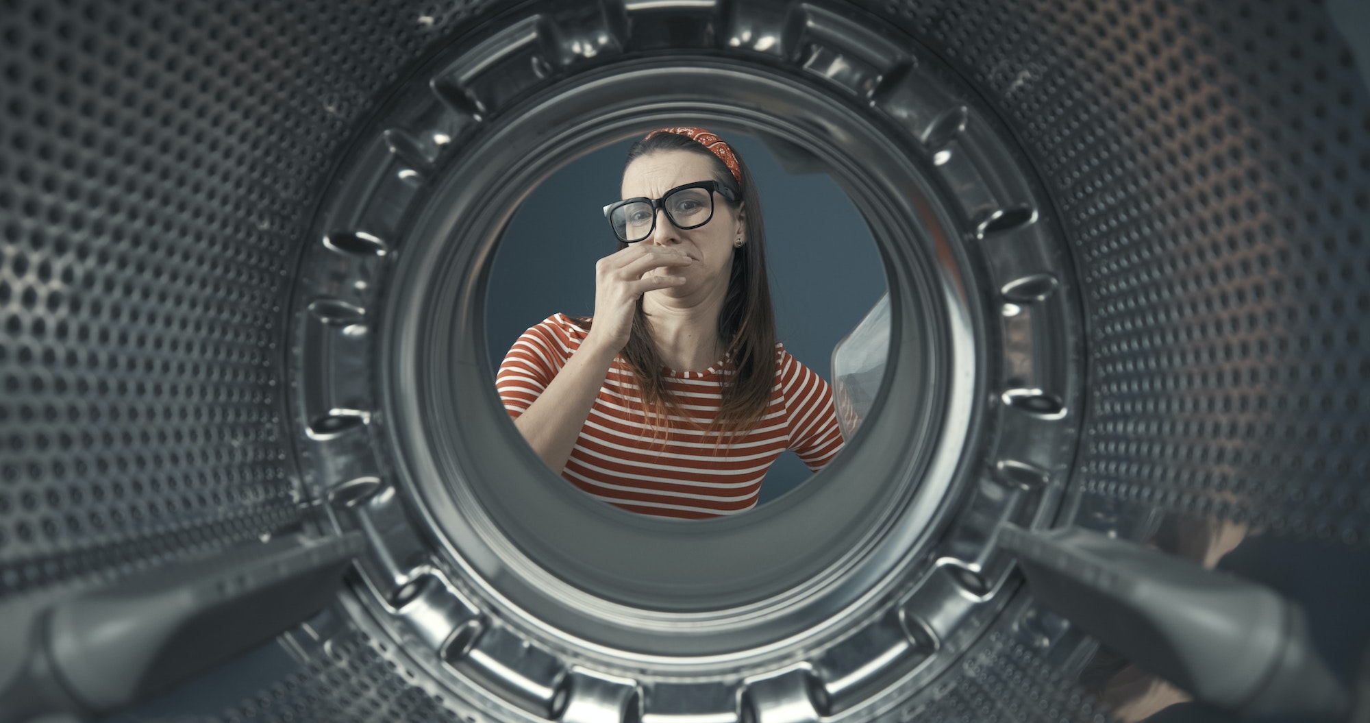 Woman looking into her smelly washing machine