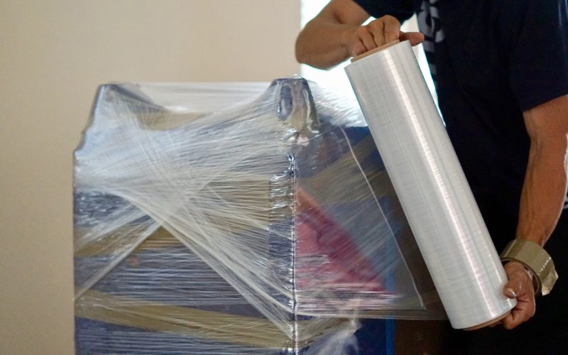 Furniture being wrapped in plastic before moving and storage